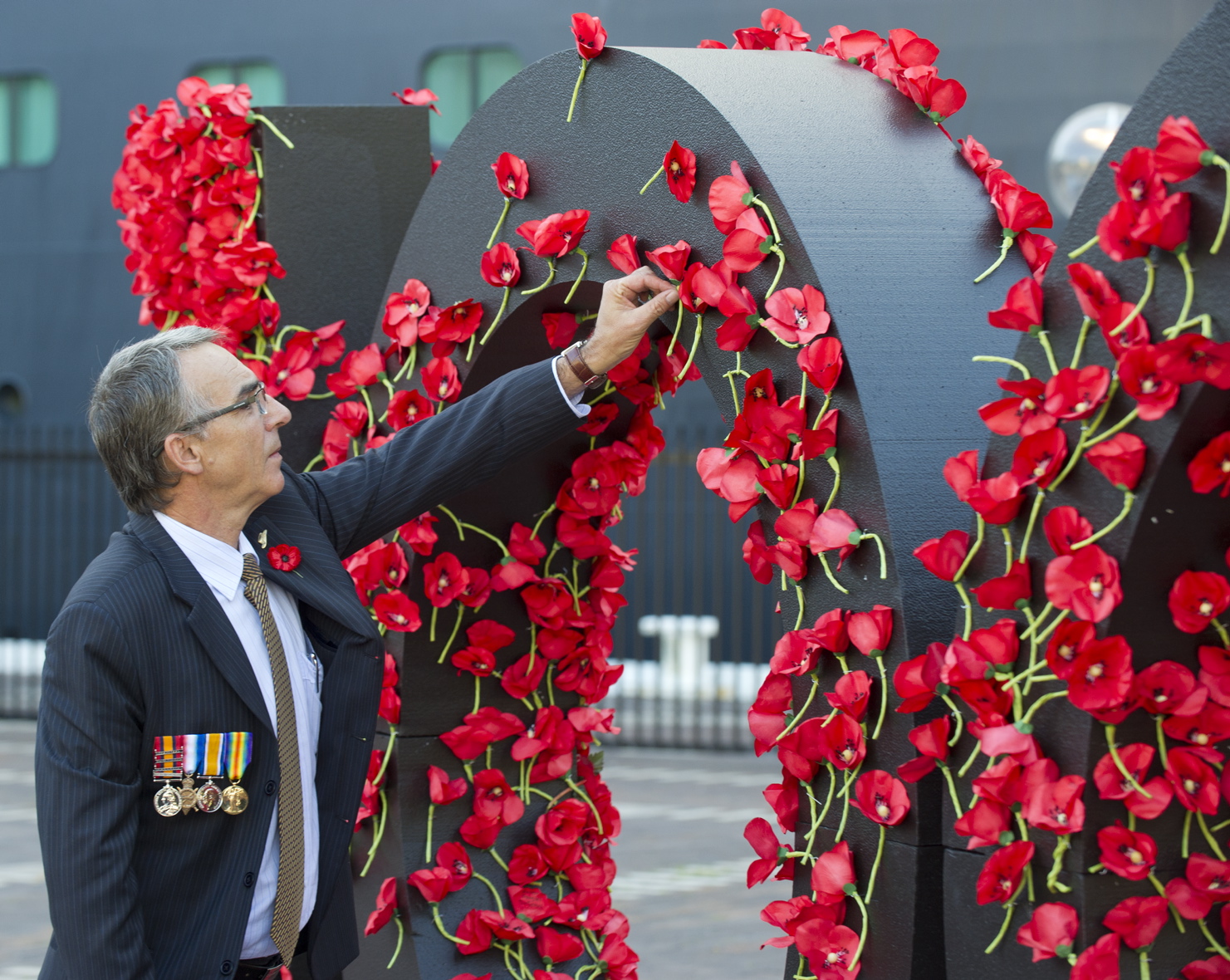 Australian Mark Keys places a poppy in the Queen Elizabeth commemorative wall